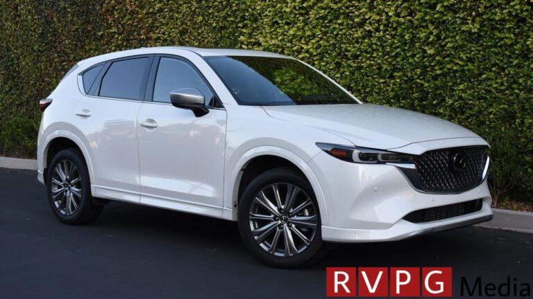2024 Mazda CX-5 Signature in white with an ivy wall in the background.